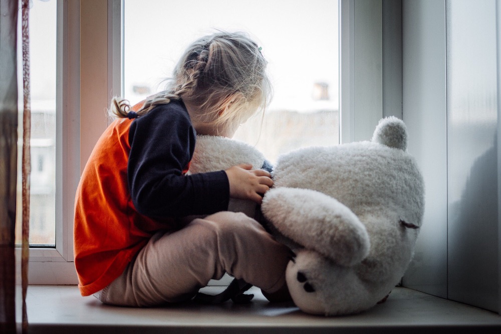 girl hugging teddy bear